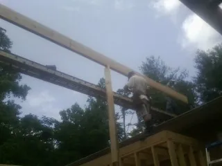 Carpenter setting a ridge beam over a new addition frame — Ice Dam Removal by Roofing Brothers in Euclid